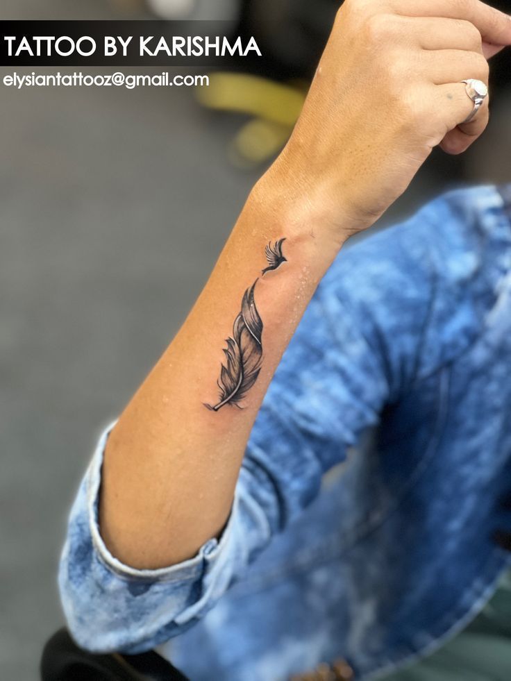 a woman's arm with a feather tattoo on the left side of her arm