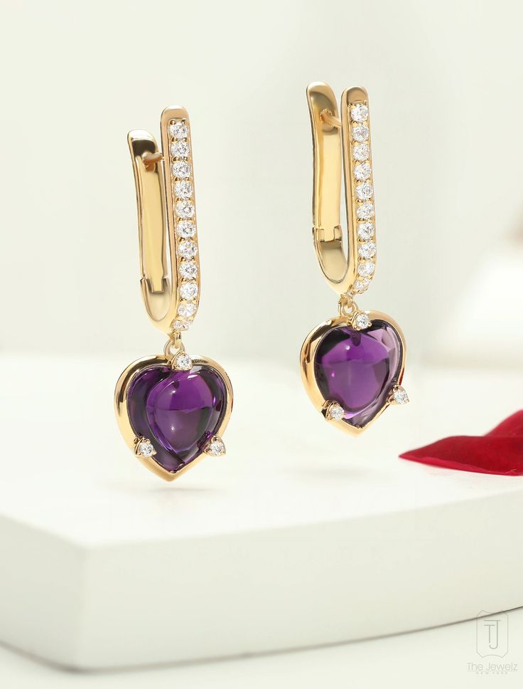 Heart-cut Amethyst earrings adorned with a cascade of diamonds, each one a reflection of the magnificent heart at its core. With every move they dance and shimmer and create an alluring aura of glamour and sophistication. Expertly crafted, the Lover's Rock Hoop Earrings feature a total gross weight of 7.28 grams, with a durable metal weight of 5.5 grams. Adorned with a stunning 8.29 carat gemstone and sparkling 0.62 carat cubic zirconia, these elegant earrings radiate sophistication and romance. Elegant White Gold Huggie Heart Earrings, Luxury Heart-shaped Diamond Earrings, Luxury Heart Cut Diamond Earrings, Luxury Heart Earrings With Diamond Accents For Formal Occasions, Luxury Diamond Earrings For Valentine's Day, Luxury Heart Earrings With Diamond Accents, Luxury Diamond Earrings With Accents For Valentine's Day, Elegant Huggie Jewelry For Valentine's Day, Luxury Heart-shaped Brilliant Cut Earrings