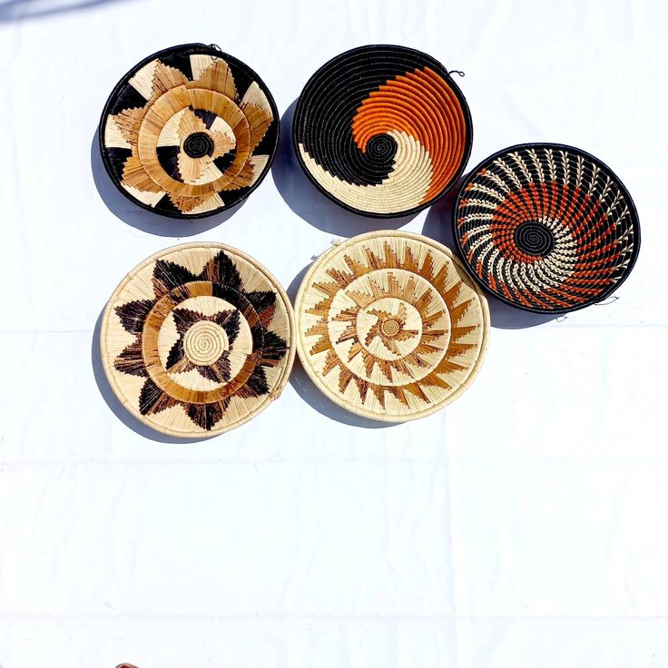 four woven baskets sitting on top of a white table