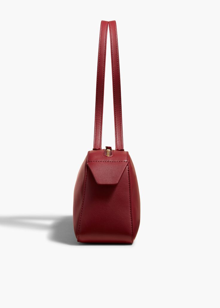 A refined and elongated silhouette that unites decisive lines with soft curves. Topped by sleek, doubled straps and a custom zipper. Suede-lined interior. Evening Structured Shoulder Bag With Smooth Grain, Classic Structured Shoulder Bag For Evening, Timeless Formal Shoulder Bag With Zipper Closure, Timeless Formal Shoulder Bag With Zipper, Classic Structured Shoulder Bag, Classic Burgundy Shoulder Bag With Adjustable Strap, Sleek Smooth Grain Shoulder Bag, Chic Burgundy Shoulder Bag With Leather Lining, Formal Structured Shoulder Bag With Leather Lining