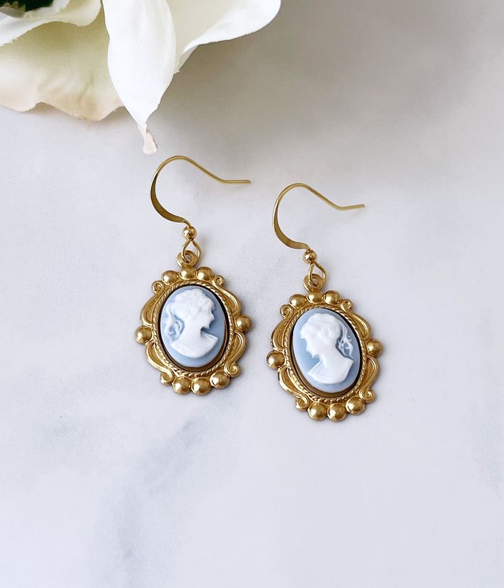 Classic resin cameos in an ornate oval brass setting with brass French ear wires. Designed and hand assembled by Robyn Joy. Cameo Drop Earrings Jewelry Gift, Cameo Drop Earrings As Gift, Gift Cameo Drop Earrings Jewelry, Vintage Cameo Drop Earrings, Gold Cameo Earrings As A Gift, Gold Cameo Earrings For Gift, Victorian Vintage Charm Drop Earrings, Victorian Oval Brass Earrings, Victorian Blue Cameo Jewelry