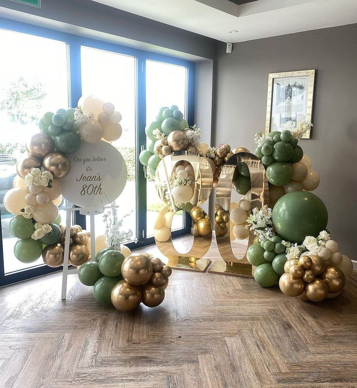 the balloon arch is decorated with gold and green balloons