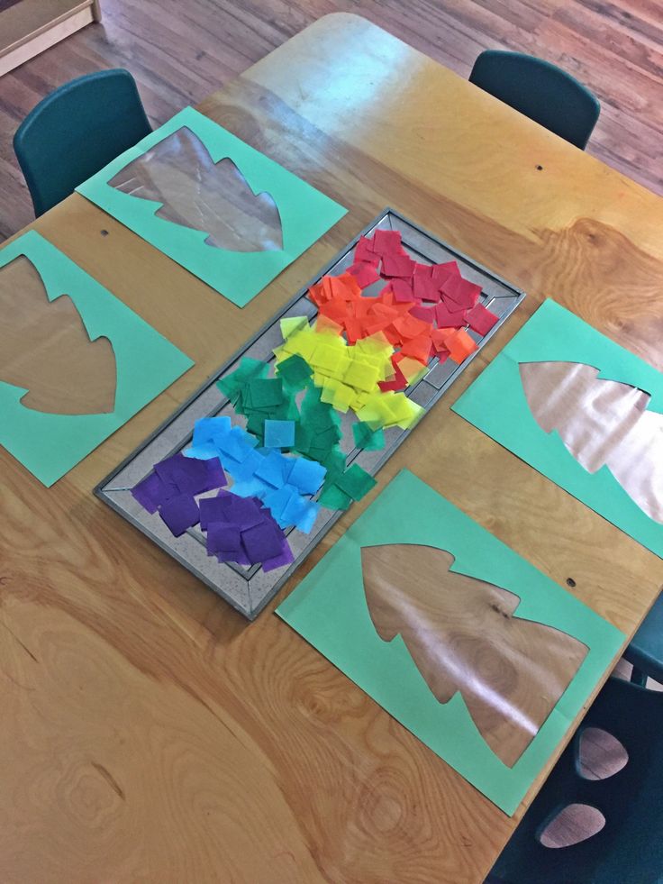 a wooden table topped with cut out pieces of paper on top of it's sides