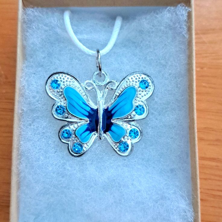 Handmade Blue Crystal Butterfly Necklace Made With Enamel Butterfly On White Cord Chain. Pendant Butterfly Measures 28mm In Shining Plated Silver. Pendant Features Enamel Blue Shades With Blue Crystal Stones. The Butterfly Is A Symbol Of Endurance And Hope. Chain Is Adjustable With Claw Clasp Closure. Box Display Only. Pouch Included Free. New And Unused Item. Contact Me With Any Offers. Blue Butterfly Sterling Silver Jewelry, Nickel-free Blue Necklace - Perfect Gift, Blue Nickel-free Necklace As Gift, Blue Nickel-free Necklaces As Gift, Nickel-free Blue Necklace Perfect For Gifts, Nickel Free Blue Necklace For Gift, Light Blue Metal Jewelry For Gifts, Blue Butterfly Necklace For Gifts, Blue Butterfly Necklace For Gift