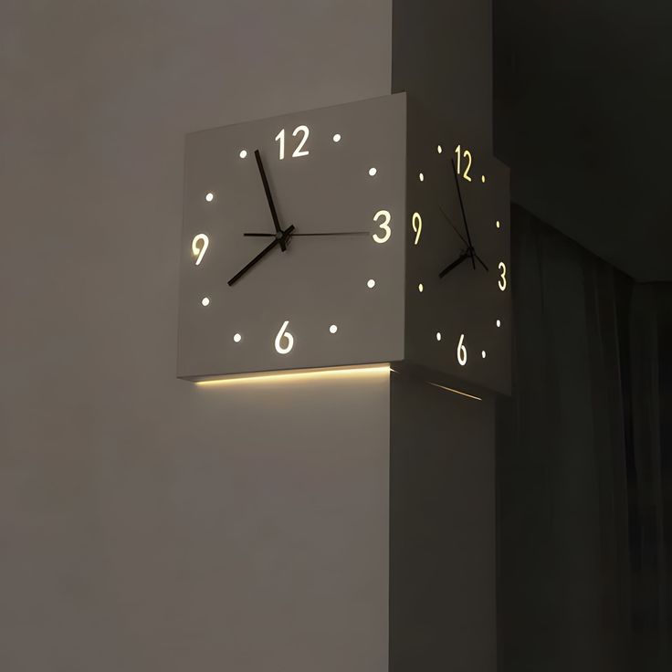 a clock that is on the side of a wall with numbers lit up below it