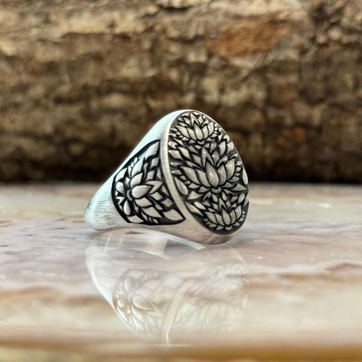 Japanese Lotus Flower Mens Ring. Oxidized Lotus Flower Band Ring, Japanese Kanji Ornamental Wedding Men's Band, Sterling Silver Nature Ring, Pisces Jewelry MATERIALS: - Solid 925 sterling silver PRODUCTION METHOD: - Handmade with Care INTERNATIONAL SHIPPING: - We use International Priority Shipping Service - 5-10 Business Days PACKAGING: - All handmade sterling silver rings are nicely packaged ready to gift in elegant jewelry boxes. - Gift for him, gift for father's day MAKER GUARANTEE: - All it Silver Ornaments Jewelry, Symbolic Carved Round Ring, Symbolic Carved Ring, Spiritual Carved Round Ring, Spiritual Silver Signet Ring For Wedding, Symbolic Engraved Signet Ring For Wedding, White Sterling Silver Signet Ring For Wedding, Wedding White Sterling Silver Signet Ring, Symbolic Silver Signet Ring For Wedding