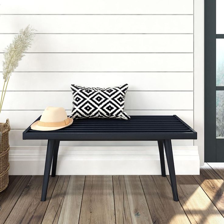 a bench sitting on top of a wooden floor next to a window