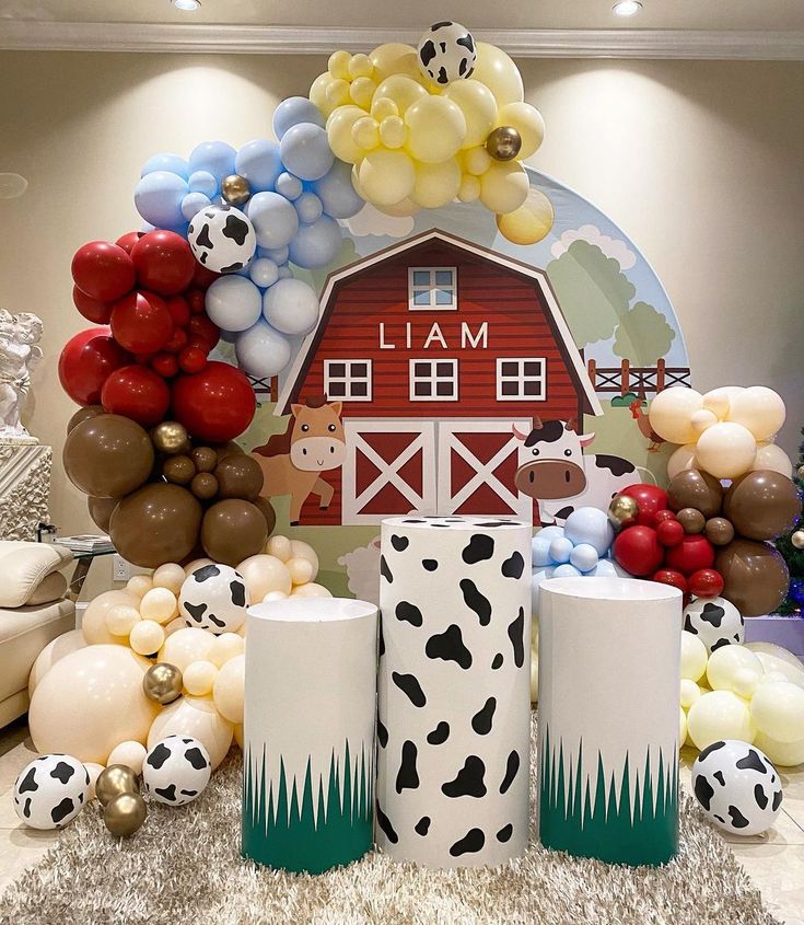 balloons and decorations are on display in front of a farm scene with a red barn