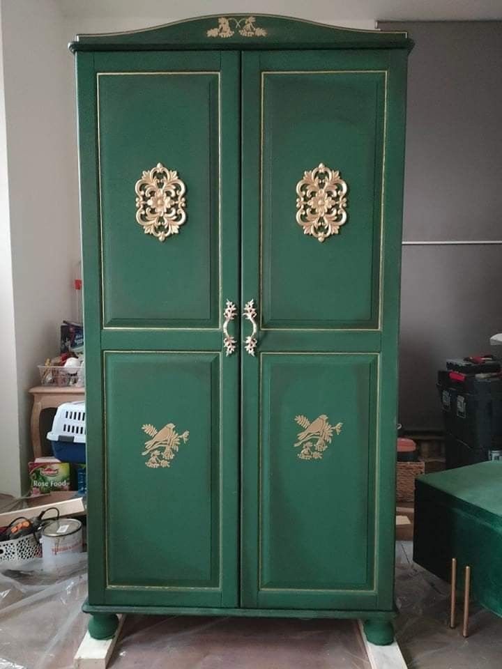 a green armoire with gold decorations on it