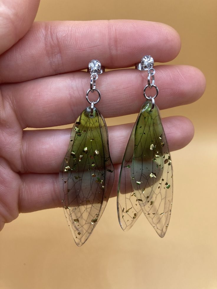 Beautiful green translucent fairy butterfly wing earrings with sparkly gold flecks that glimmer in the light! Suspended on hypoallergenic & nickel-free stainless steel rhinestone studs. Super lightweight and cute! Green Butterfly Earrings, Tinkerbell Earrings, Translucent Butterfly, Butterfly Wings Earrings, Fairy Earrings, Fairy Butterfly, Wishlist 2024, Butterfly Wing Earrings, Fairy Jewelry