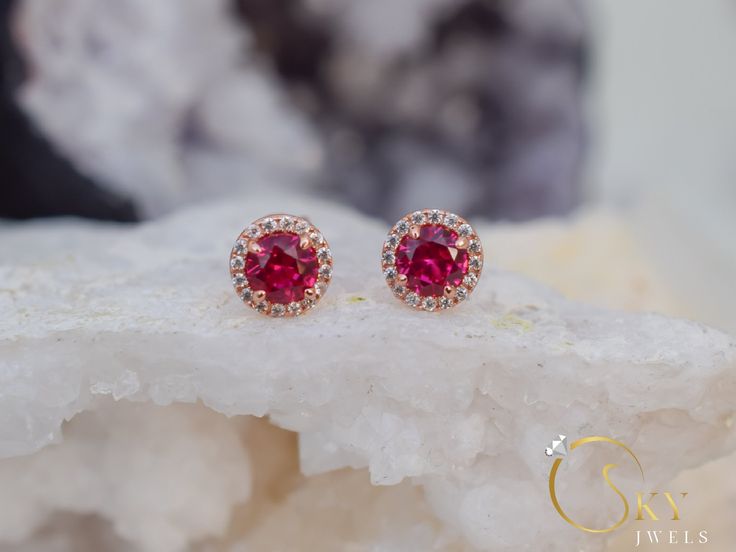 Rose gold ruby halo earrings, with a delicate yet eye capturing design. The stones have a stunning dark red color that gives you a mesmerizing effect with the accented stones all around. The Ruby is the birthstone of July. It represents love and passion. For centuries, this gem has been considered the king of all gems for its rarity, hardness (second only to a diamond), beauty and apparently mystical powers. Rubies have been the prized possession of emperors and kings throughout the ages, and to Round Halo Design Jewelry For Valentine's Day, Red Halo Design Earrings For Wedding, Red Round Cluster Earrings For Wedding, Ruby Halo Design Earrings For Wedding, Ruby Halo Earrings For Wedding, Wedding Ruby Earrings With Halo Design, Wedding Earrings With Lab-created Ruby Gemstone, Ruby Earrings With Halo Design For Wedding, Anniversary Ruby Earrings With Halo Setting