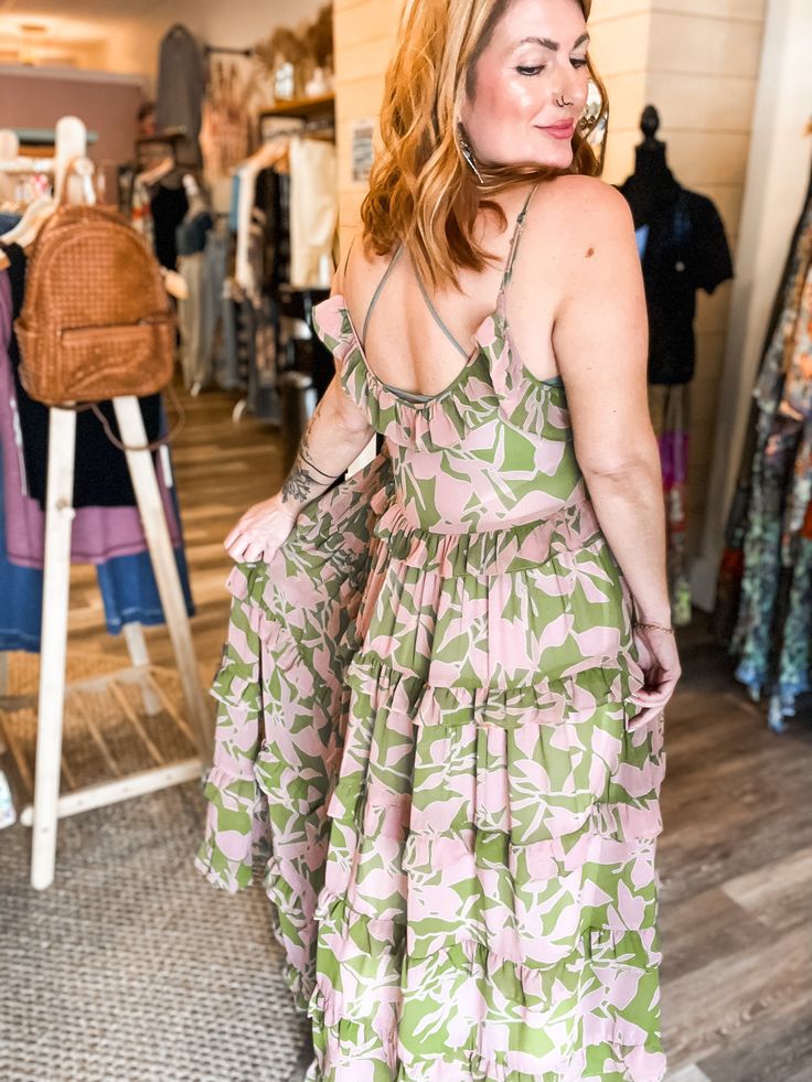 Get ready to turn heads with the Lina abstract floral maxi! This tiered maxi dress features a beautiful abstract floral print and ruffle detailing, adding a touch of whimsy to your look. Look effortlessly stylish and playful in this statement piece! relaxed fit small fits 0-6 medium fits 8-12 large fits 12-16 100% POLYESTER imported Breezy Summer Maxi Dress With Ruffles, Flowy Tiered Dress For Summer, Green Floral Ruffled Dress For Beach, Feminine Tiered Skirt Maxi Dress For Beach, Pink Maxi Dress With Ruffled Straps For Vacation, Green Floral Ruffled Dress For The Beach, Flowy Tiered Printed Dress, Feminine Tiered Maxi Dress For Beach, Green Floral Dress With Ruffles For Beach