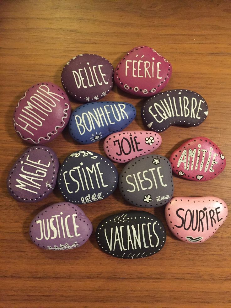 painted rocks with words on them sitting on a table