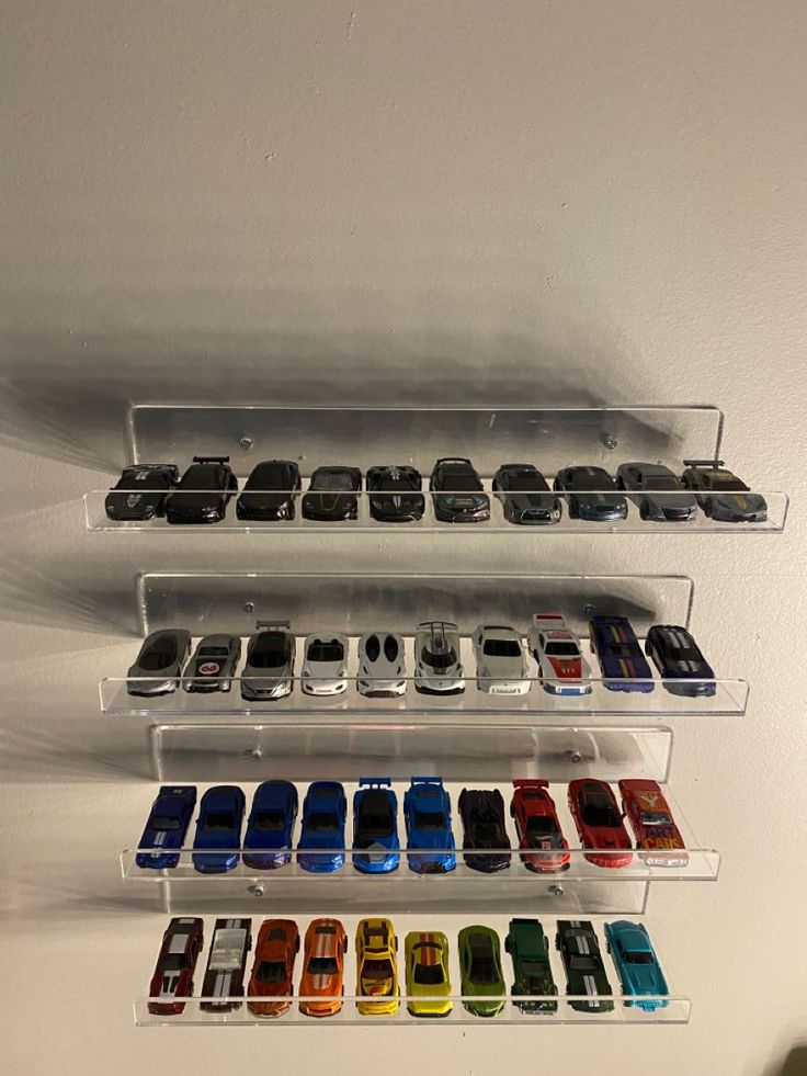 there are many cars on the wall in this display case that is filled with them