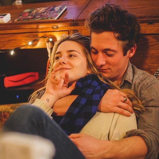 a man and woman cuddle together on the couch