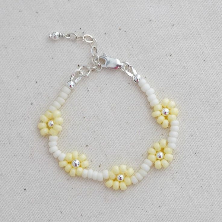 Our daisy chain beaded bracelets can be personalised with an initial or symbol disc add on. They are the sweetest keepsake jewellery for your little ones. Lovingly hand beaded using only high quality seed beads. Metal hardware options : 14k Gold filled, 14k Rose gold filled or Sterling Silver. Each bracelet comes with an extra 0.5" extension chain so your little one can still wear their bracelet as they get older. Handcrafted in Australia. Each piece is hand stamped & there may be slight variati White Dainty Beaded Bracelet With Flower Charm, Dainty White Beaded Bracelet With Flower Charm, White Flower-shaped Bracelet With Tiny Beads, White Delicate Adjustable Friendship Bracelets, Delicate Adjustable White Friendship Bracelets, Delicate White Adjustable Friendship Bracelets, White Daisy Bracelets As Gift, Dainty Handmade White Beaded Bracelets, Delicate White Round Beaded Bracelets