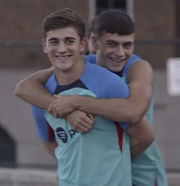 two young men are hugging each other outside