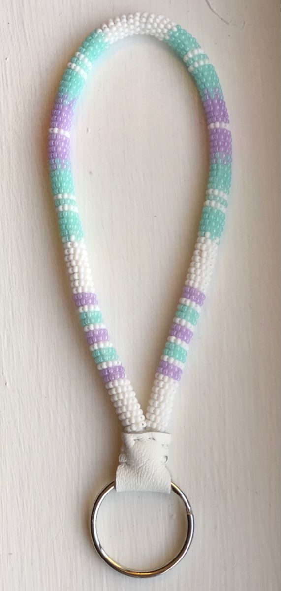 a white and purple lanyard with a metal ring hanging from it's end