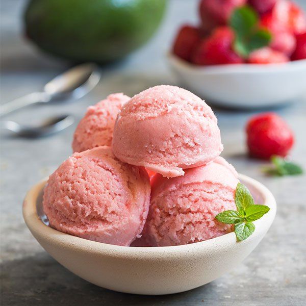 three scoops of strawberry ice cream in a bowl