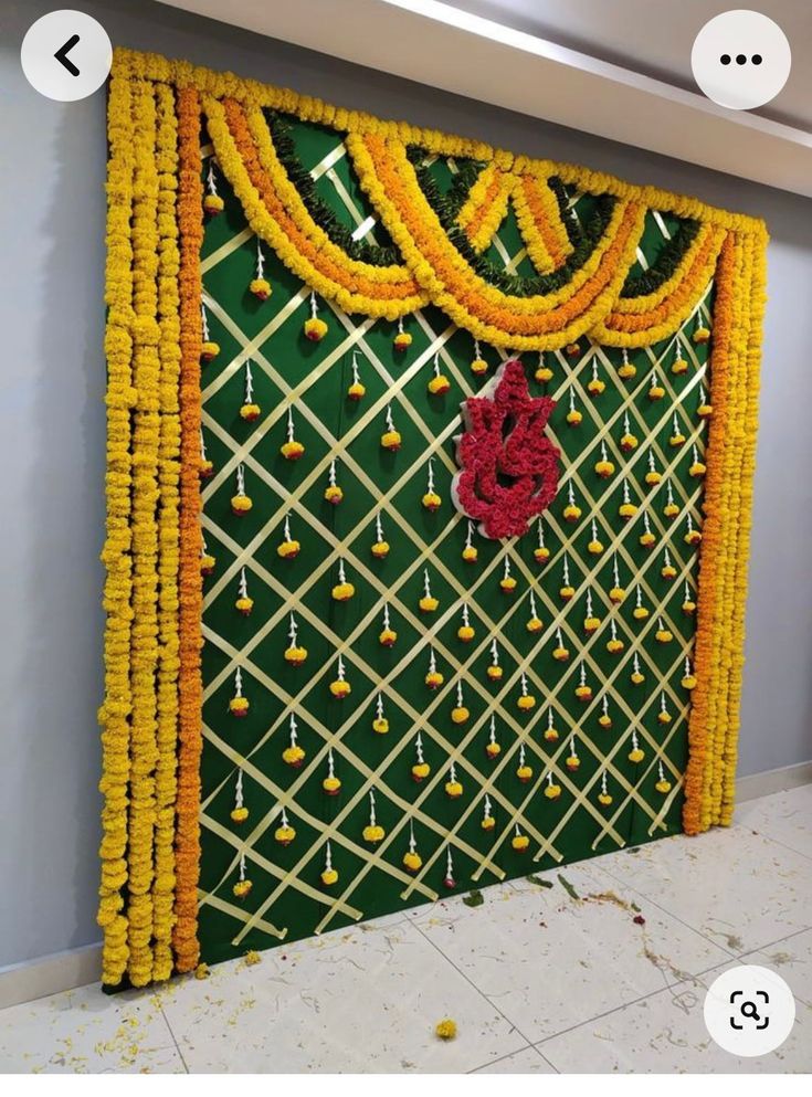 the wall is decorated with yellow and red garlands on it, along with other decorations