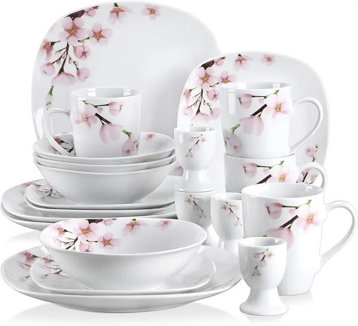 a white dinner set with pink flowers on it