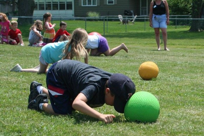 children playing with balls in the grass on a sunny day