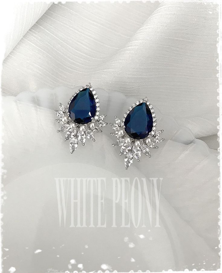 "Something Blue for your special day Art Deco - The Great Gatsby & Downton Abbey inspired sapphire royal blue crystal pear drop / leaf and pearl stud earrings : \"SCARLETT\" by ©White Peony by KC. Beautiful and sparkling crystal earrings are made of AAA quality large sapphire royal blue and clear Cubic Zirconia (zircon, CZ) / white gold plated components and hand embellished with small 3mm Swarovski crystal pearl (photo shown in \"white\"). If you don't need peal, you can choose \"no pearl\" Sapphire Jewelry With Sparkling Stones For Wedding, Elegant Blue Hand-set Bridal Earrings, Elegant Hand Set Blue Bridal Earrings, Blue Wedding Jewelry With Matching Earrings, Elegant Blue Crystal Earrings For Wedding, Elegant Blue Crystal Wedding Earrings, Hand-set Blue Bridal Earrings For Wedding, Teardrop Sapphire Wedding Jewelry, Hand-set Blue Bridal Earrings As Gift