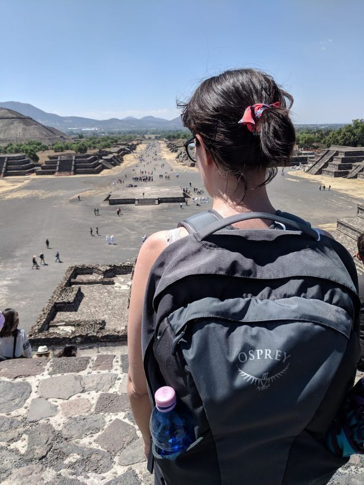 a woman with a back pack looking out over the ruins at tempelum