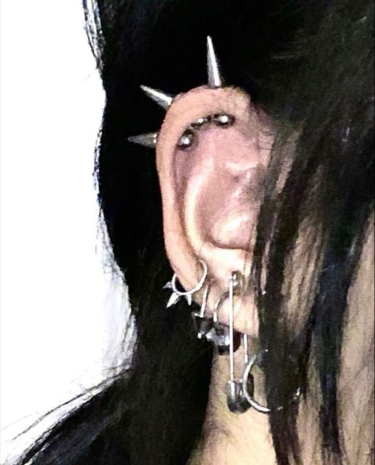 a close up of a person with piercings on their nose and ear rings attached to them