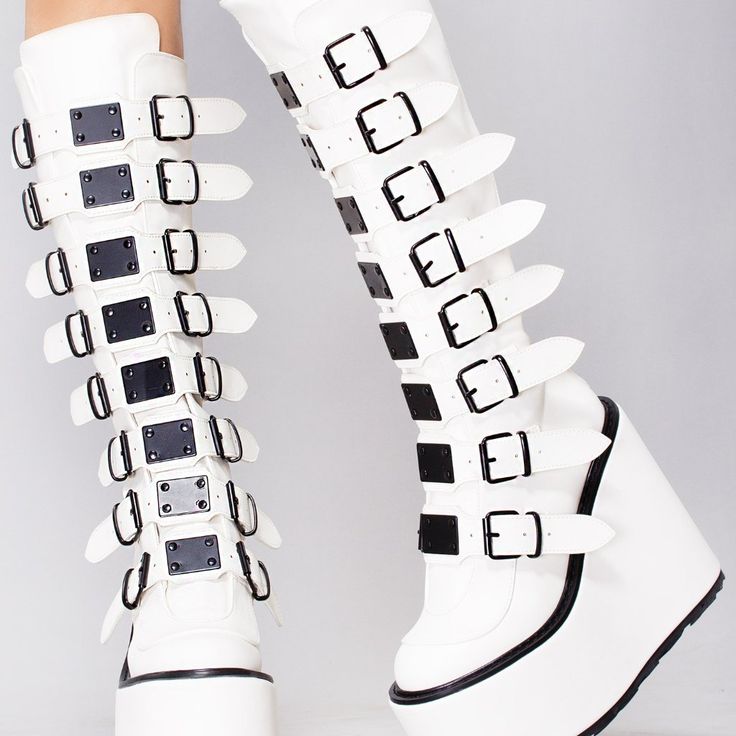 They Won’t Be Able To Get Enough Of You In The Addiction Platform Boots From Demonia. These Intoxicating Festival Boot Feature A White Vegan Leather Upper, Buckle Up Front With 8 Straps, Black Hardware And Trim, And Back Zipper Closure. You In These Cute Boots Will Be A Euphoria Better Than Any Drug Can Give! Addiction Platform Boots 5 1/2"" Platform Vegan Leather Knee High Boot 8 Buckle Straps W/ Metal Plates Detail Black Hardware & Trimback Metal Zip Closure White/Black White Platform Boots With Wedge Heel, White Closed Toe Platform Boots For Party, White Knee-high Synthetic Boots, White Platform Boots With Pointed Toe And Reinforced Heel, White Leather Platform Boots With Pointed Toe, White Wedge Heel Boots For Spring, White Leather Platform Boots With Reinforced Heel, White Platform Boots With Pointed Toe, White Leather Platform Boots With High Heel