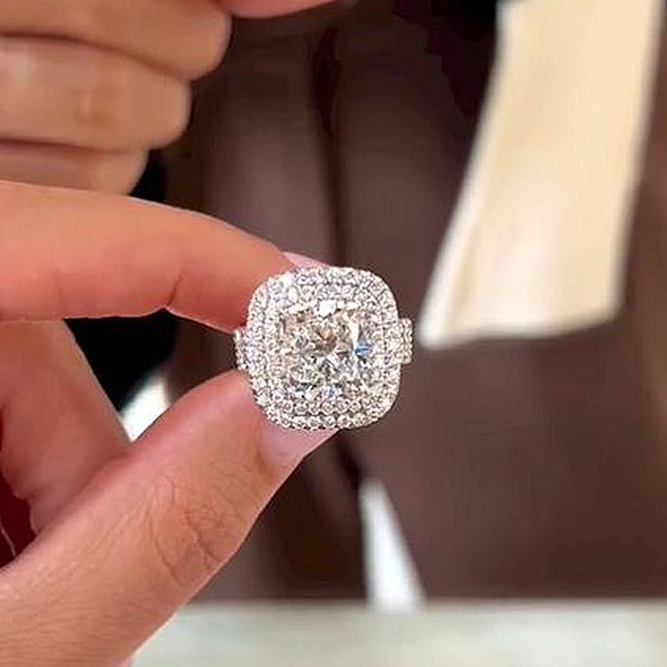 a close up of a person holding a diamond ring