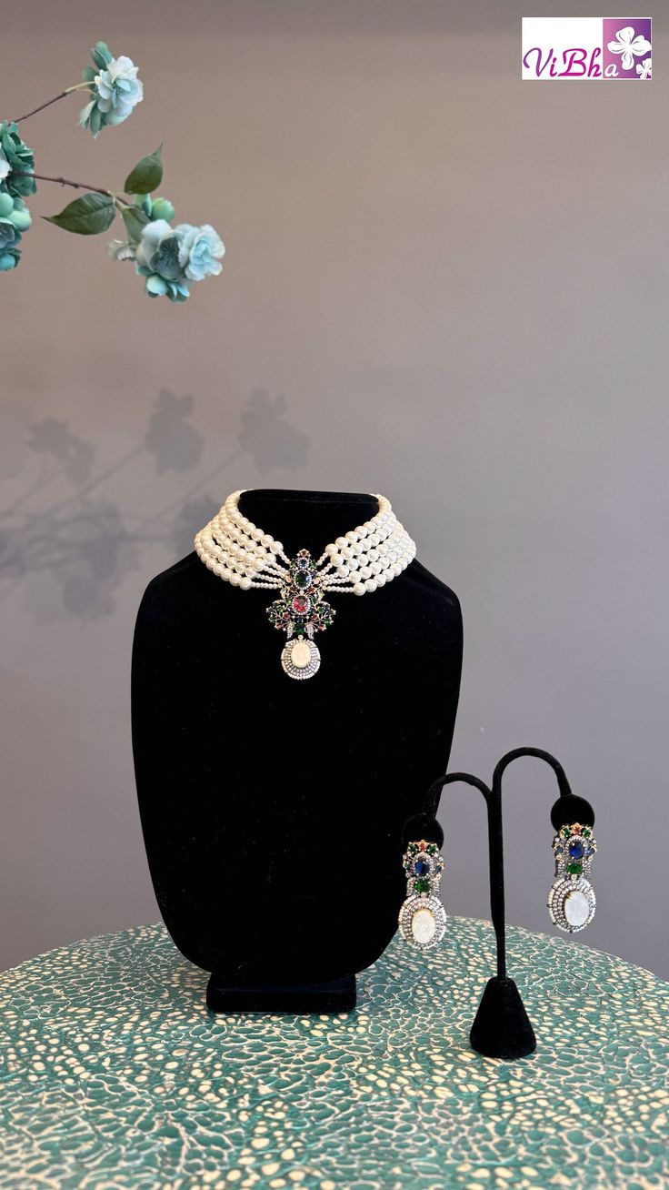 Indulge in luxury with our elegant Pearl 5-Line Choker set. Adorned with ruby emeralds, sapphires, and ADs, this pendant and earring set adds a sophisticated touch to any outfit. Its versatility allows it to be worn with various ensembles, exuding a regal charm. Elevate your style with this exclusive set. Elegant Jeweled Emerald Jewelry, Elegant Multi-stone Emerald Necklace For Formal Occasions, Elegant Festive Multi-stone Jewelry Sets, Elegant Multi-stone Jewelry Sets For Gifts, Elegant Multi-stone Jewelry Sets As A Gift, Elegant Multicolor Gemstone Emerald Necklace, Formal Multi-stone Emerald Jewelry, Elegant White Emerald Jewelry, Elegant Multicolor Gemstone Necklace