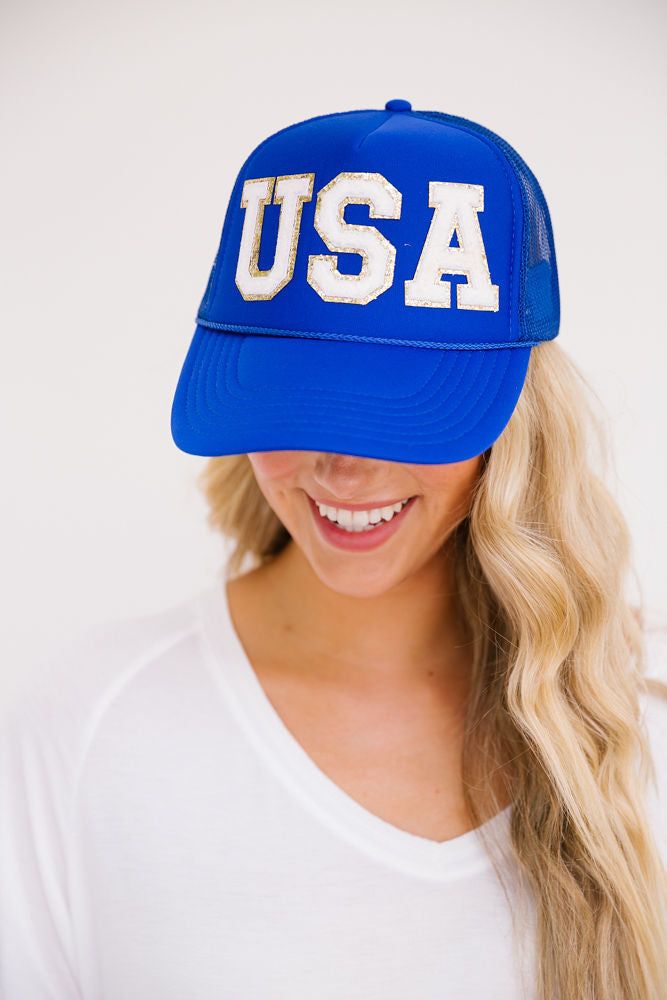 This USA hat is perfect for showing your American pride and spirit at the beach, gym, a hike, or just to cover up a bad hair day. The smiley face patch on the side is sure to put a smile on your face as well! Trucker Hat Product details: Snapback style Ponytail opening Mesh in the back of hat 100% Polyester All orders are currently shipping within 14 business days. To receive item quicker, expedited shipping is available at checkout. Patriotic Blue Trucker Hat For 4th Of July, Adjustable Blue Trucker Hat For 4th Of July, Blue Baseball Cap For 4th Of July, Casual Blue Trucker Hat For 4th Of July, Sporty Blue Hats For Summer, Sporty Blue Summer Hats, Blue Baseball Cap With Upf 50+, Adjustable Blue Trucker Hat For Beach, Blue 5-panel Trucker Hat For Baseball Season