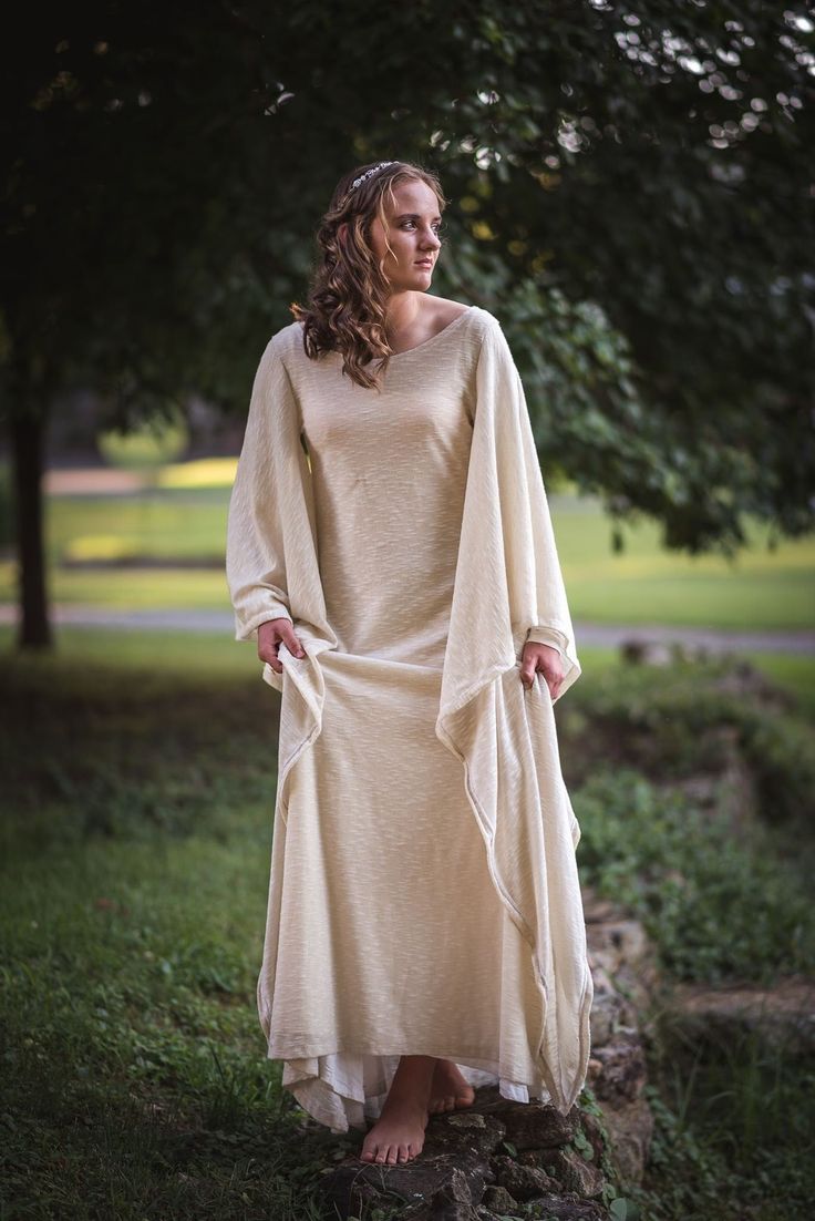 "This is a really lovely Medieval style dress averages 60\" long from top of shoulder to hem in the colors of your choice. It has long angel sleeves that can be tied up or left long, and a fitted inner sleeve. It is fully lined and can be one of the most comfortable gowns you'll ever owned. Cinch it in at the waist with a belt or corset. All purchases are nonrefundable and colors may vary based on what can be found. I've had people come up with some pretty outlandish requests before. For the bes Fitted Elven Style Festival Dresses, Fitted Medieval Dress For Summer, Spring Medieval Fitted Dress, Fitted Medieval Style Summer Dress, Fitted Medieval Summer Dress, Medieval Style Dress For Summer Larp, Medieval Style Dress For Larp In Summer, Medieval Summer Dress For Larp, Bohemian Dresses For Larp And Medieval Festivals