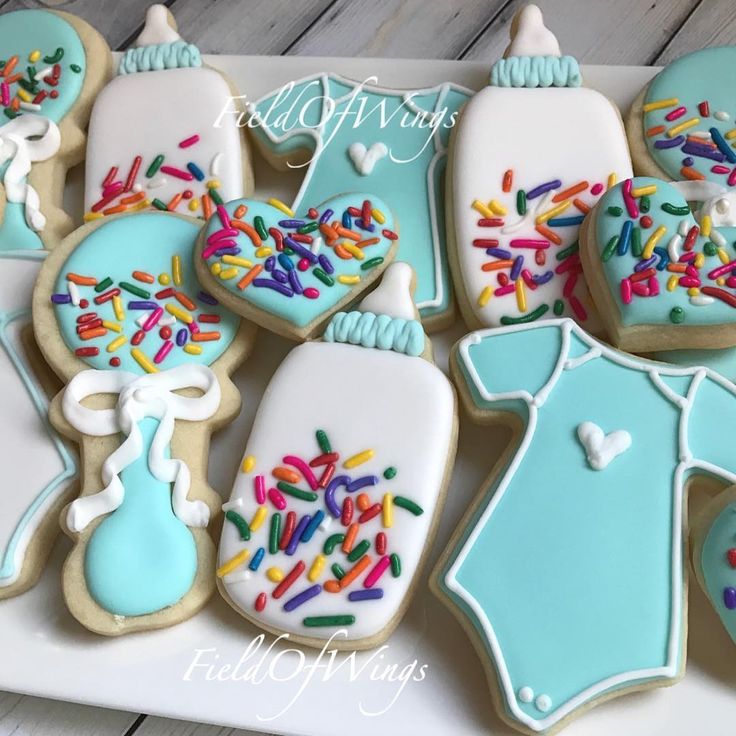 decorated cookies with blue icing and sprinkles on a white platter