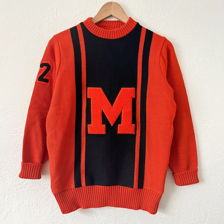 true vintage 1970's varsity sweater  orange and black colors with orange "M" and "72" right sleeve patches. 100% virgin wool. Whiting brand. Chain stitched name "Perez" on tag. fits size medium  18.5" chest, 25" length  great worn condition Retro Sweater For College In Fall, Vintage Orange Sweater For Fall, Vintage College Sweater For Winter, Vintage Sweater For College In Winter, Vintage Winter Sweater For College, Vintage College Sweater For Fall, Vintage Sweater For College In Fall, Vintage Fall Sweater For College, Colors With Orange