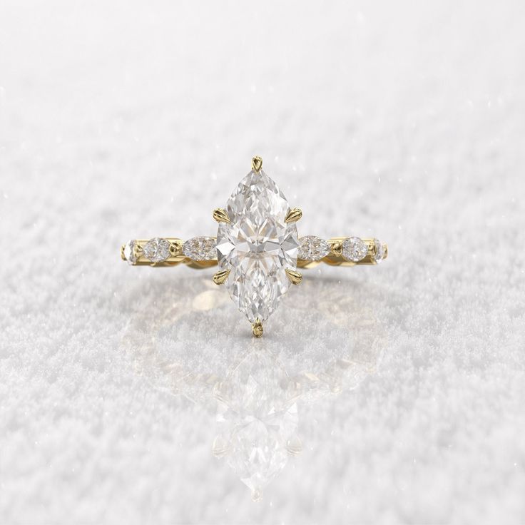 an engagement ring with a pear shaped diamond in the center and side stones on each side