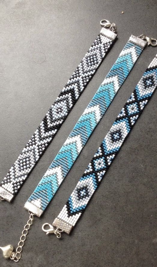 two bracelets are sitting on a table next to each other, one is blue and the other is white