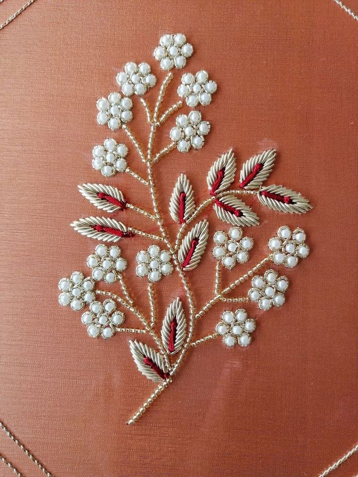 a close up of a piece of cloth with beading on it and flowers in the middle