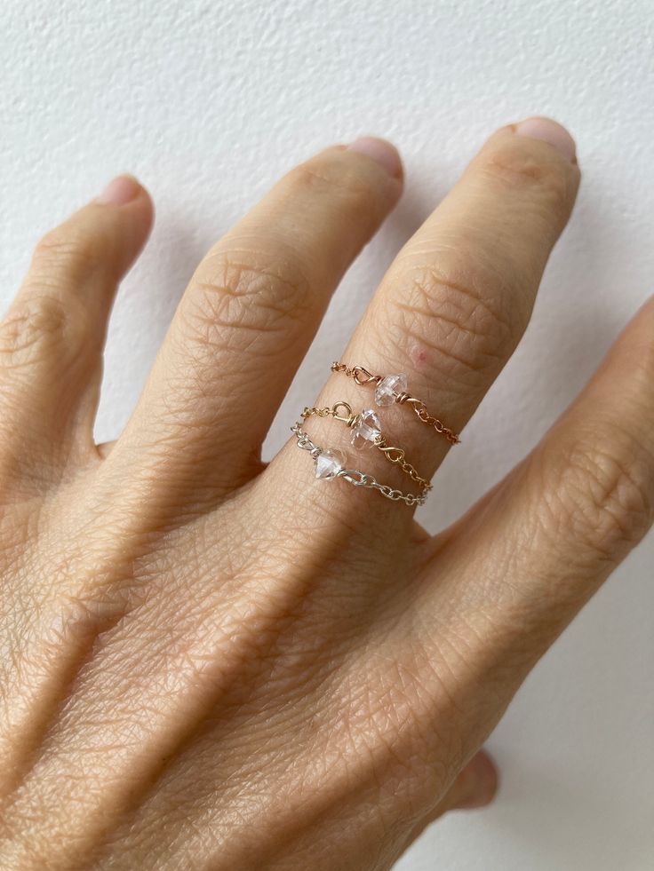 "This little chain ring offers a fresh take on a traditional band ring. It is also very lightweight and comfortable to wear.  D E T A I L S *It features a small  Herkimer diamond. Each of these is unique in shape and size. *Herkimer diamonds are actually double  terminated quartz crystals. The \"diamond\" in their  name is due to both their   clarity and natural  faceting. *Choose between a 14k gold filled, 14k rose gold filled or sterling silver chain.  *Ring comes with a matching crystal infor Rose Gold Sterling Silver Crystal Ring For Promise, Silver Promise Ring With Diamond Cut, Silver Diamond Cut Chain Ring For Promise, Sterling Silver Midi Rings In Rose Gold For Wedding, Rose Gold Sterling Silver Jewelry With Rose Cut Diamonds, Dainty Rose Gold Diamond Crystal Ring, Dainty Rose Gold Promise Ring Jewelry, Rose Gold Dainty Jewelry For Promise, Wedding Midi Rings In Sterling Silver And Rose Gold