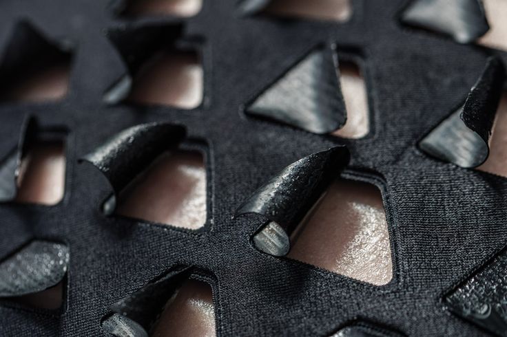 close up view of black and silver shapes on fabric with holes in the middle to make them look like they have been made out of metal