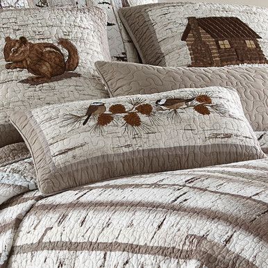 the comforter is made up with brown and white quilts, along with an image of a cat