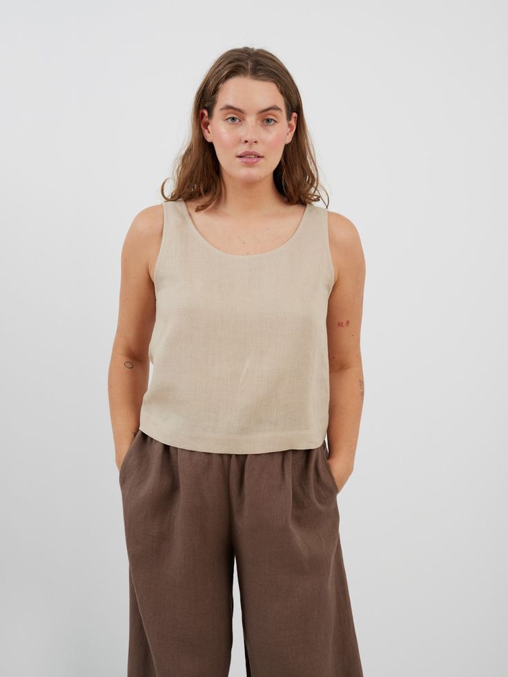 "CALI is a sleeveless tank top with scoop neckline and relaxed fit. DETAILS - Scoop neck - Sleeveless design - Straight cut - Oeko-Tex certified 100% local washed midweight linen - Cut and sewn to order just for you in our studio COLOR - Beige, you can also choose other colors above - Fabric samples are available here https://www.etsy.com/listing/586569696/linen-fabric-samples SIZING & FIT - Fits true to size - Model is 5'6\" / 172 cm and wearing a size M CARE FOR LINEN - Machine wash up to 30ºC/86ºF gentle cycle - Lay flat to dry or tumble dry low - Warm iron if needed - Do not bleach SIZE GUIDE Size conversion guide Size XS (US 0-2, IT 36-38, UK 4-6, Japan 3-5, France 32-34) Size S (US 4-6, IT 40-42, UK 8-10, Japan 7-9, France 36-38) Size M (US 8-10, IT 44-46, UK 12-14, Japan 11-13, Fran Relaxed Scoop Neck Summer Tops, Casual Cotton Tank Top With Scoop Back, Summer Cotton Camisole With Scoop Back, Summer Cotton Scoop Back Camisole, Casual Scoop Back Tank Top For Summer, Everyday Summer Camisole With Scoop Back, Basic Sleeveless Crop Top For Everyday, Casual Linen Tank Vest, Relaxed Everyday Scoop Neck Tops