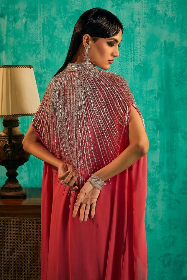 Hot pink georgette cape with intricate silver crystal embellishments and asymmetric sleeves. Paired with an embellished kurta and sharara.
Components: 3
Pattern: Embroidered
Type Of Work: Crystal, Bead
Neckline: High collared
Sleeve Type: Asymmetric
Fabric: Georgette
Color: Pink
Other Details: 
Model Height: 5 ft 7 inches, wearing size S
Occasion: Mehendi and Haldi, Sangeet - Aza Fashions Hand Embellished Dupatta For Party Wear, Hand Embellished Dupatta For Party, Hand Embellished Blouse Piece For Party Wear, Party Wear Hand Embellished Blouse For Festive Season, Festive Hand Embellished Party Wear Blouse Piece, Festive Hand Embellished Party Wear Blouse, Party Wear Hand Embellished Georgette Anarkali Set, Designer Georgette Gown Hand Embellished, Designer Hand Embellished Georgette Gown