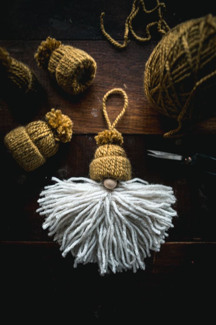 some yarn and scissors are laying on the table next to it's tassels