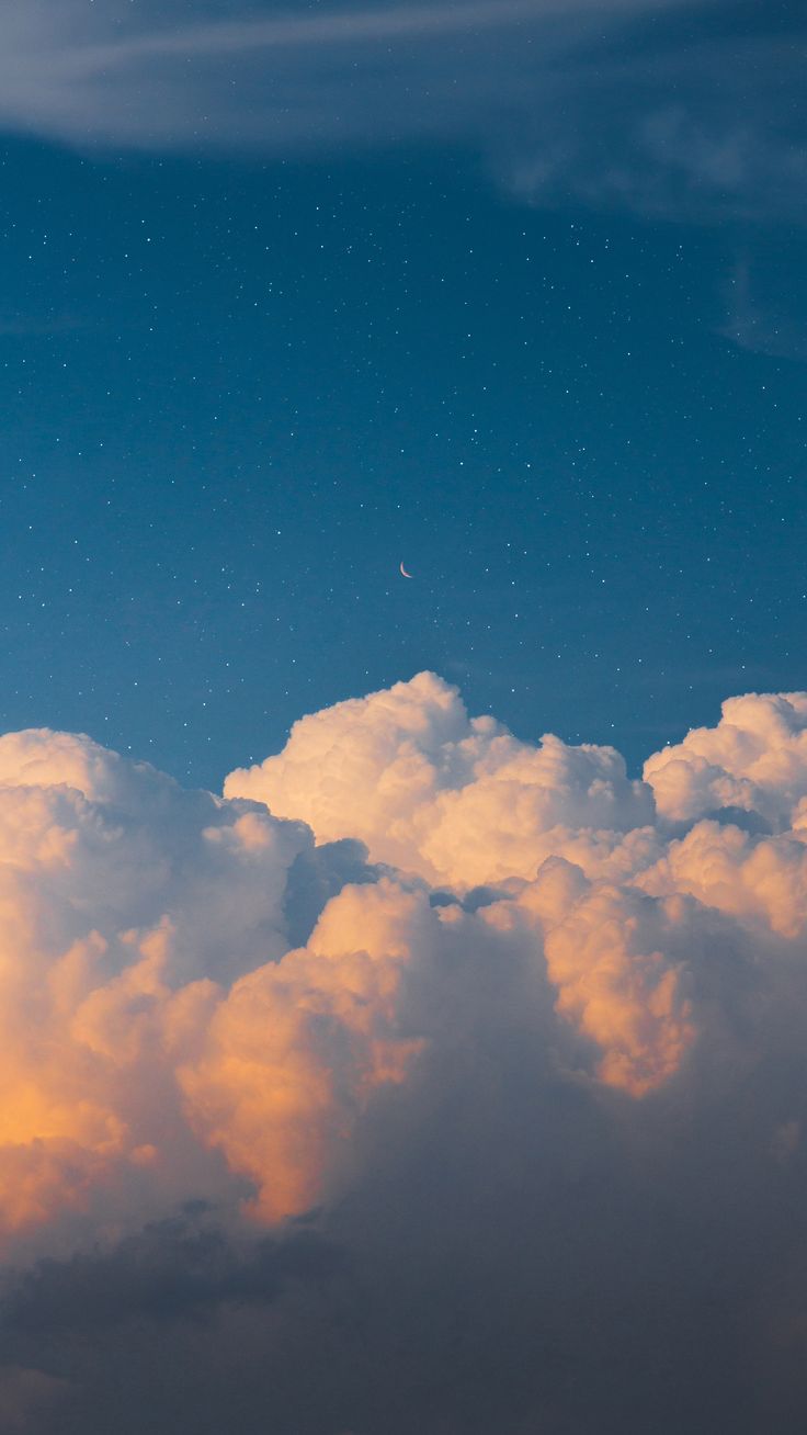 the airplane is flying high in the sky above the clouds at sunset or sunrise time