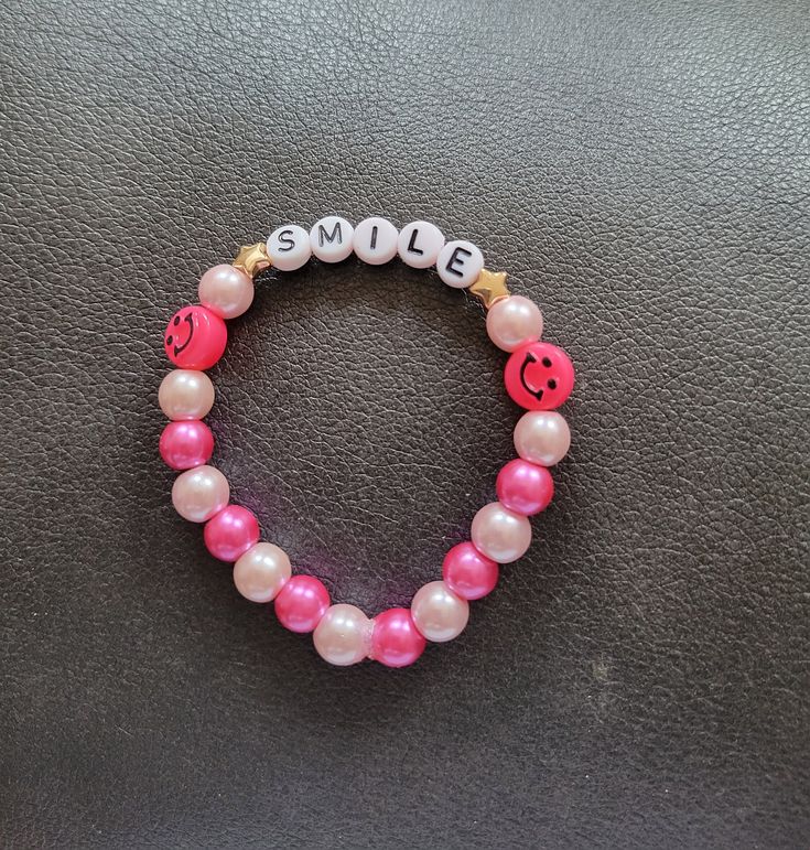 Pink Smile bracelet made with light and dark pink alternating round beads. Elastic band. Can be customized. Pink Friendship Bracelets With 8mm Round Beads, Adjustable Pink Bracelets With Letter Beads, Pink Adjustable Rosary Bracelet For Friendship, Adjustable Handmade Pink Rosary Bracelet, Adjustable Pink Rosary Bracelet For Friendship, Pink Name Bracelet With Colorful Beads For Friendship, Pink Wristband With Letter Beads As Gift, Adjustable Pink Wristband With Letter Beads, Adjustable Pink Beaded Bracelets With 8mm Beads