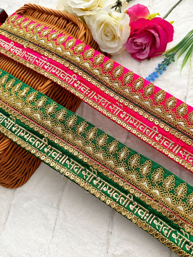 three different colored bangles sitting next to each other on a white table with flowers in the background