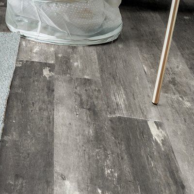 a wooden floor that has been cleaned and is next to a glass vase with flowers in it