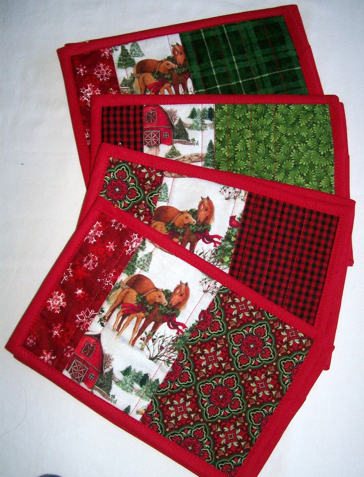 four placemats with horses and snowflakes on them, one is red